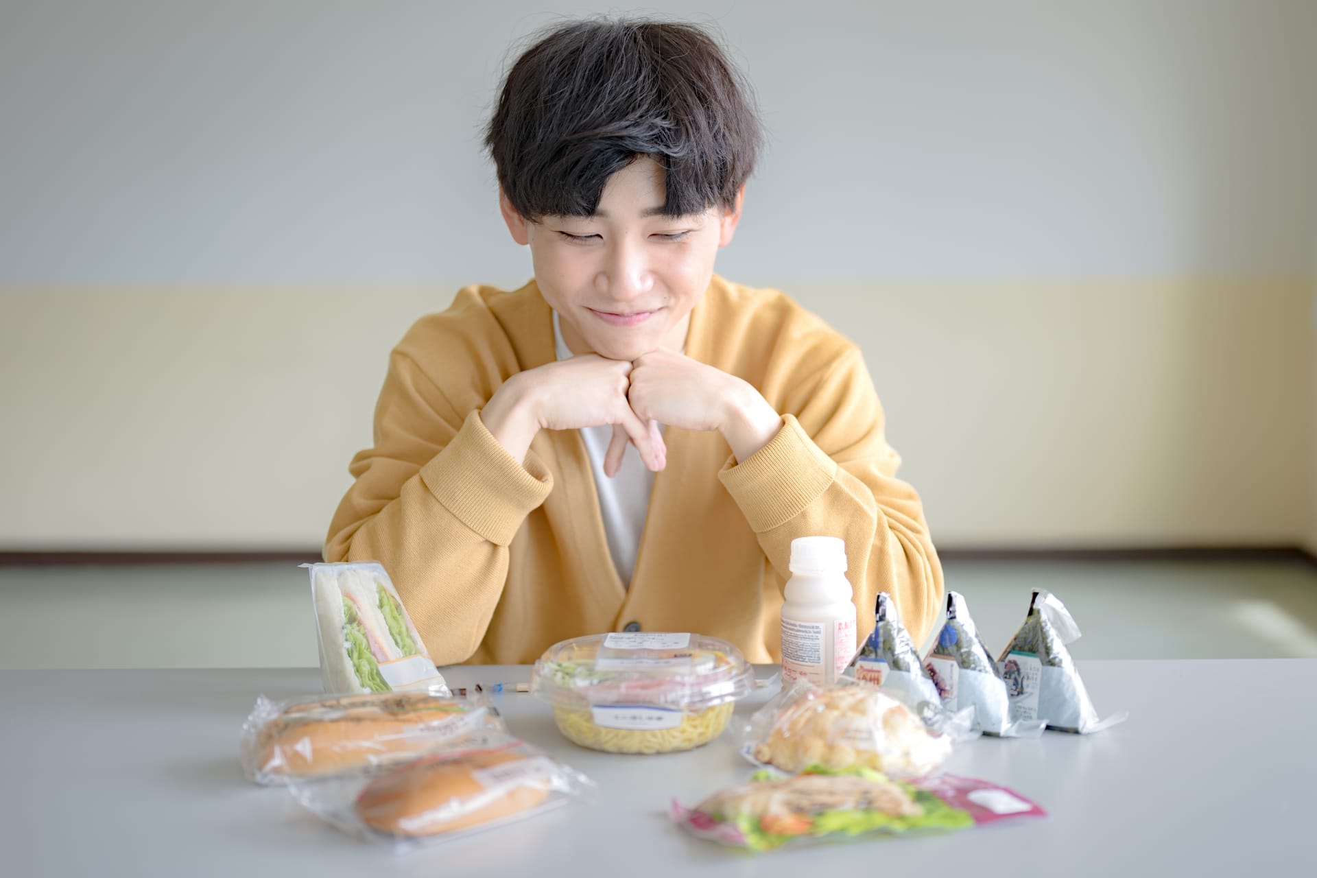 コンビニのご飯を眺める男性