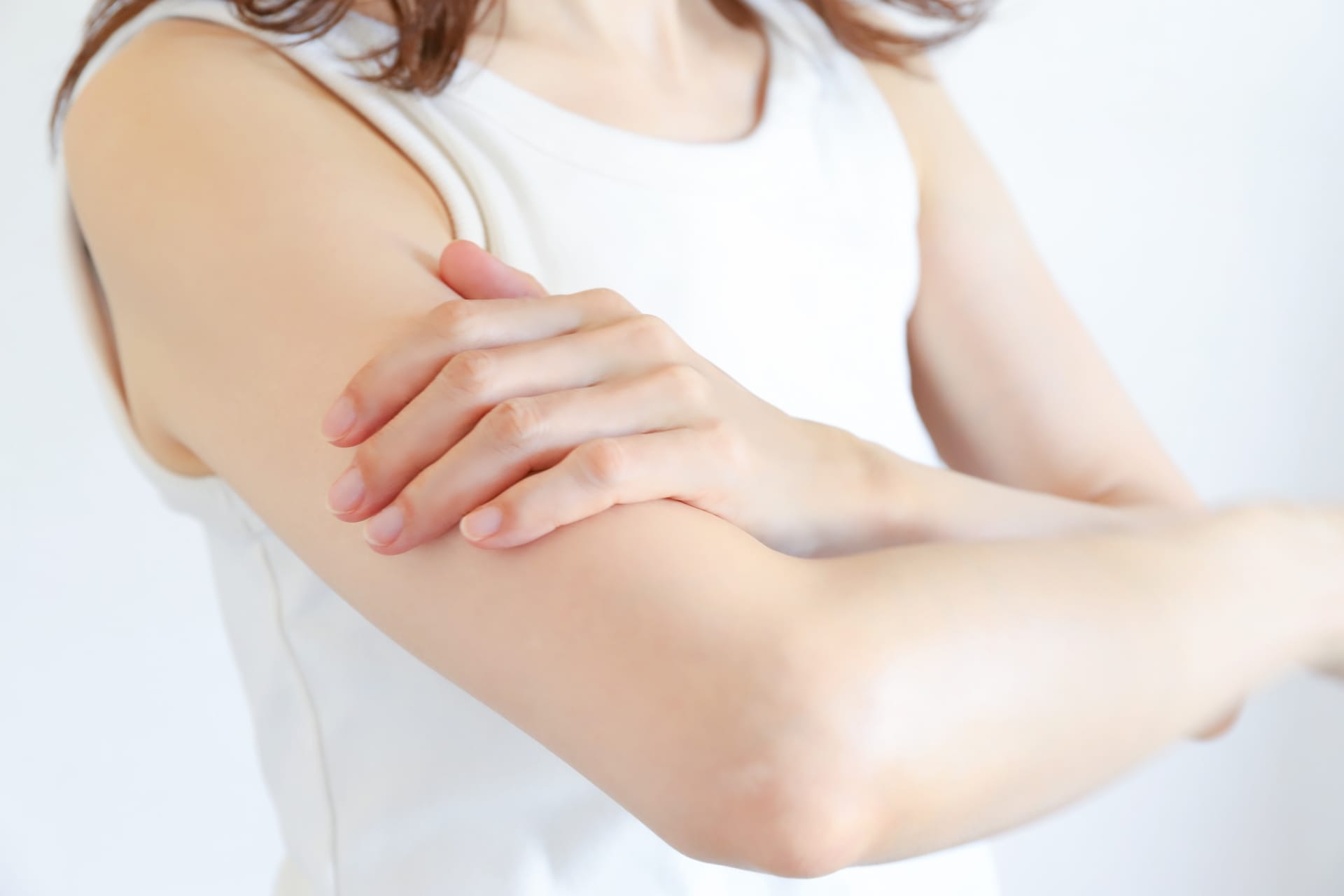 腕を触る女性の画像