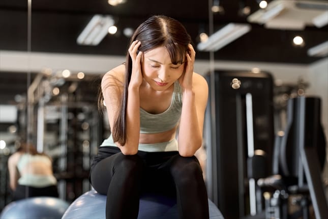 ジムで頭を抱える女性