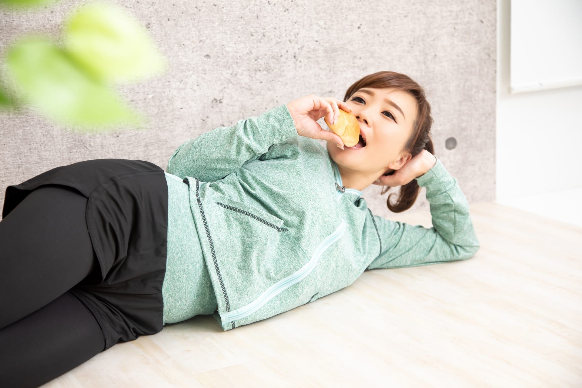 寝そべって食べ物を食べる女性